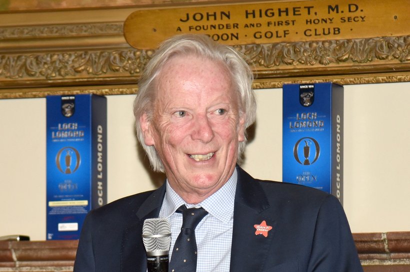 Man standing on stage announcing an award