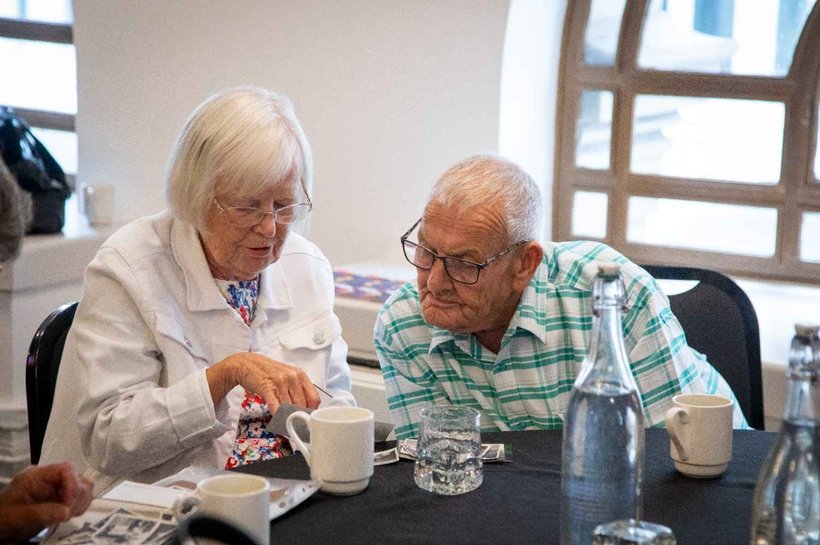 An older woman and an older man looking at photographs