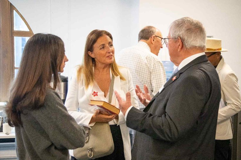 Three people talking and smiling, gesturing with their arms
