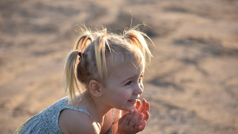 Happy young girl playing on the beach