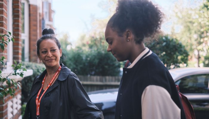 Young girl approaches new foster home with support worker, acted by Chan, one of Action for Children's young ambassadors