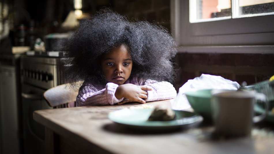 Alice a hunry sad girl sits at a table looking at empty plates