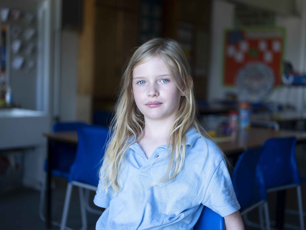 blonde-girl-looking-at-camera-in-a-school
