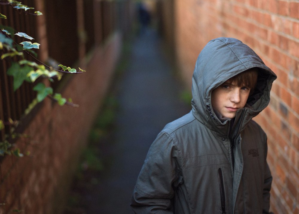 boy in alley looking worried