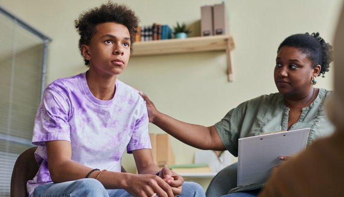 Boy sat down in a support appointment with a woman