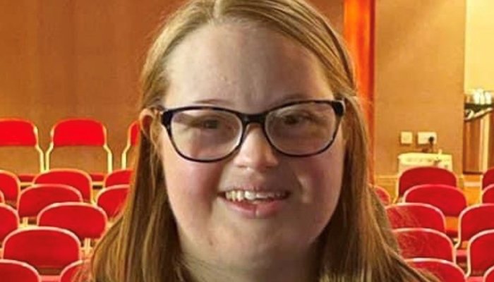 Carmela holding a microphne smiling at the camera