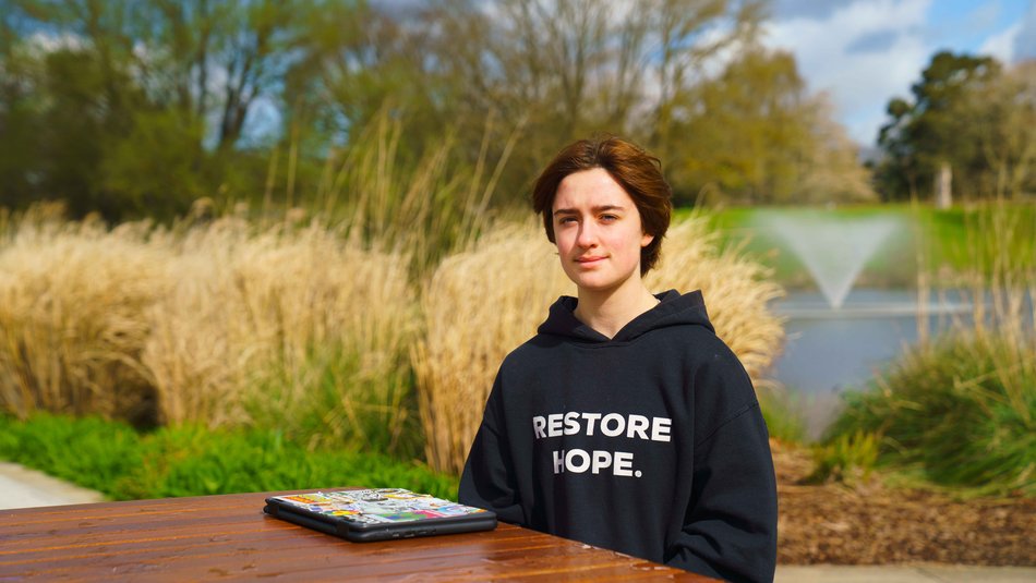 Charlie sitting outside with water fountain behind