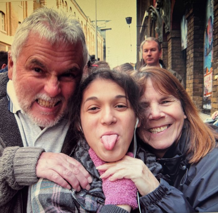 Foster parents Derrick and Sue smile either side of Lauren, who is sticking her tongue out