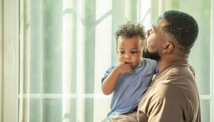 Father holding son looking into distance