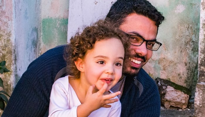 Father with daughter sitting on step outside
