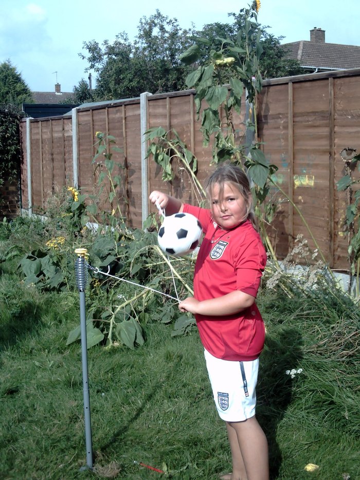 Georgia, an Action for Children young campaigner, playing with her football in the garden