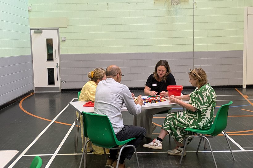 Group of people sat round a table in an indoor gym