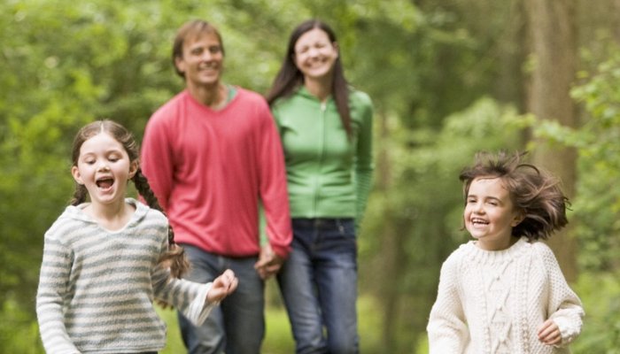 Happy family walking in woods