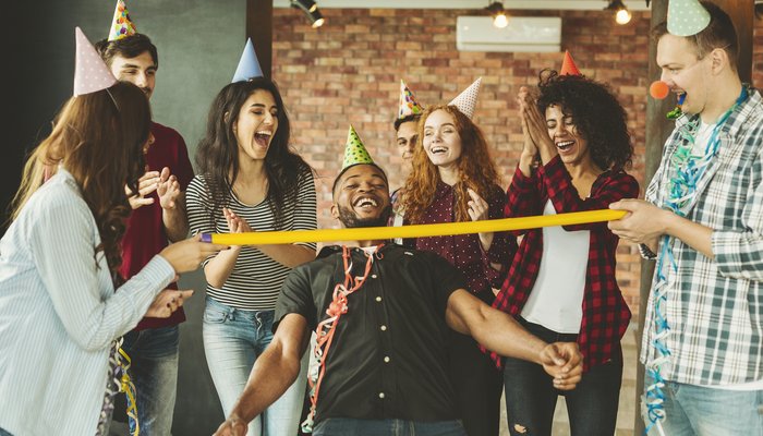 Happy friends playing Limbo at party