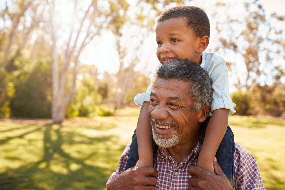 Happy grandfather with toddler boy sitting on his shoulders.jpg
