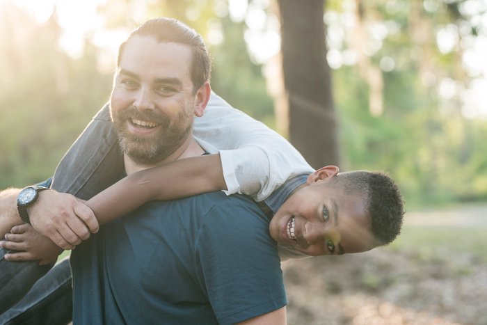 Happy son and father playing in woods