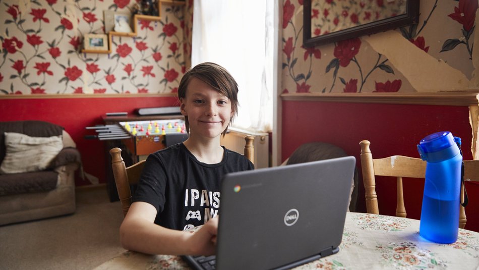 Jacob with his Dell laptop smiling at the camera