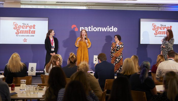 Katherine Woods speaking onstage at a Nationwide event