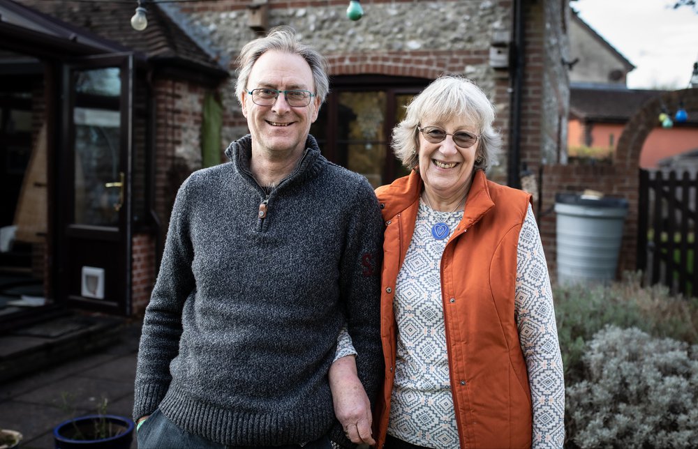Kelvin and Heather smiling at the camera standing in their garden