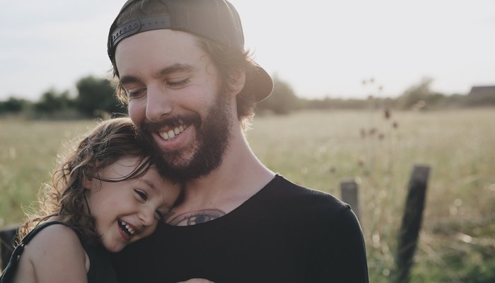 Laughing girl hugging young father