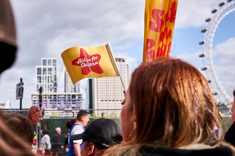 Action for Children flag waving against the London Eye at the London Marathon