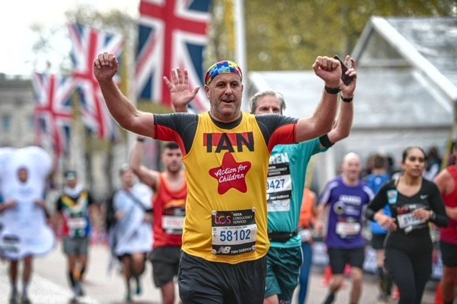 Action for Children runner cheering whilst running down Pall Mall at the London Marathon