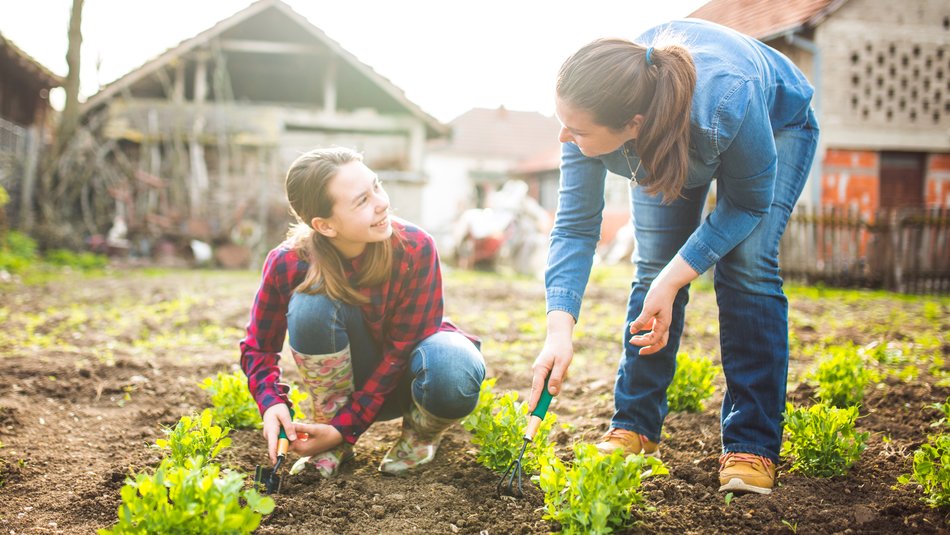 Mother and daughter working in garden