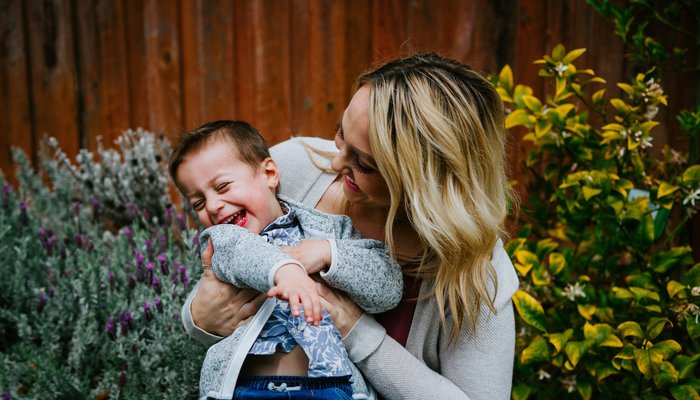 Mother and son laughing together in a garden