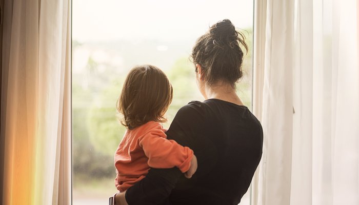 mother holding child looking out of window.jpg