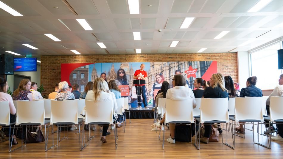 Man standing on a stage talking to an audience