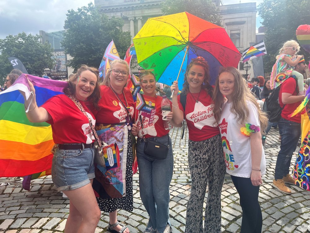 Group at Pride in 2023 with flags and banners