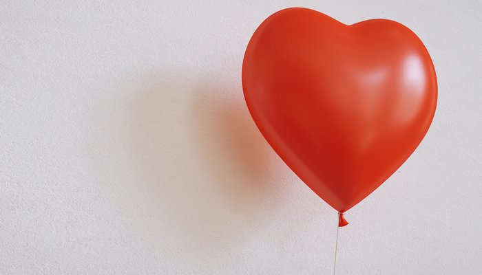 Red heart-shaped balloon against white background.jpg