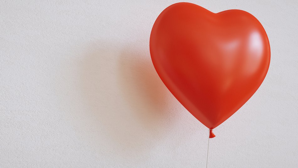 Red heart-shaped balloon against white background.jpg