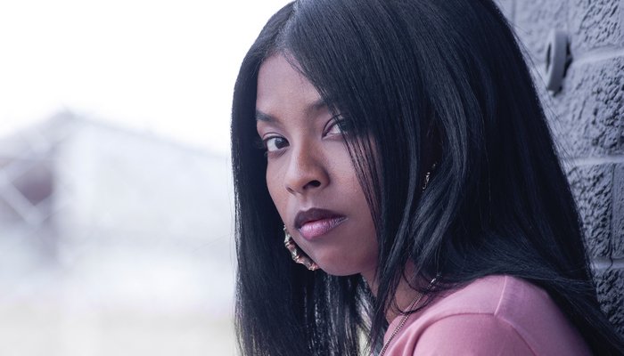 Serious teen leaning against wall