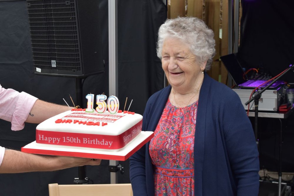 Sister Eluned Williams MBE blowing out candles on Action for Children's 150th birthday