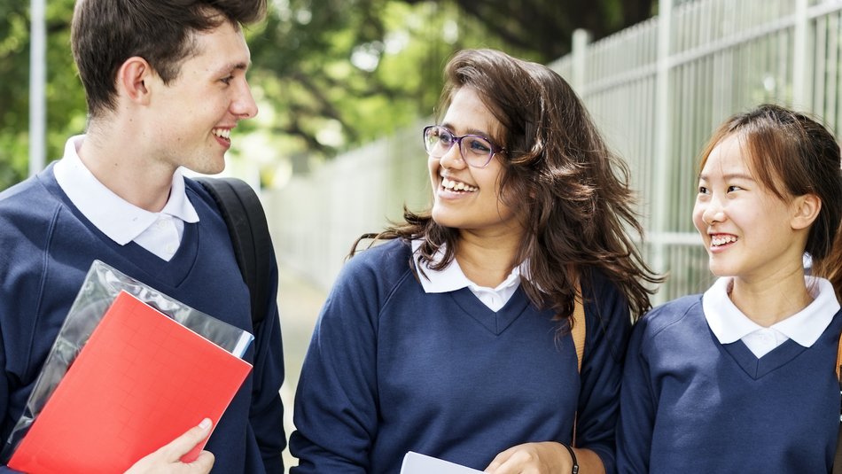 Teen school mates walking in the street with big smiles on their faces.jpg
