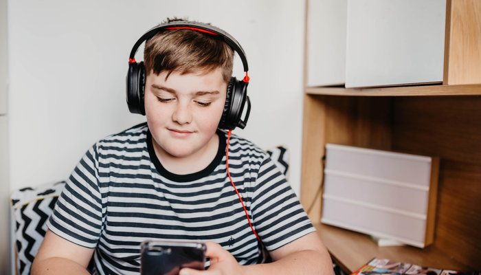 Teenage boy listening to music in his room.