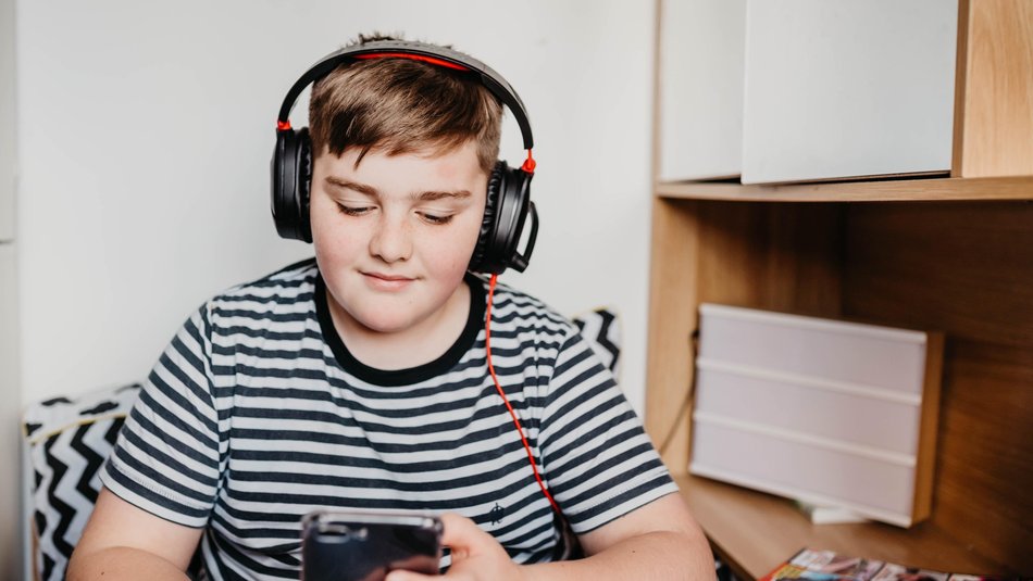 Teenage boy listening to music in his room.