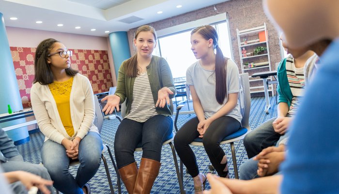Teenage girls sitting in a circle and having disuccsion