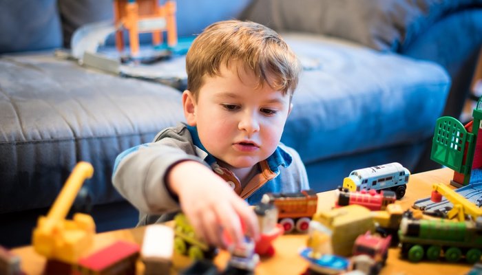 boy playing with train toy