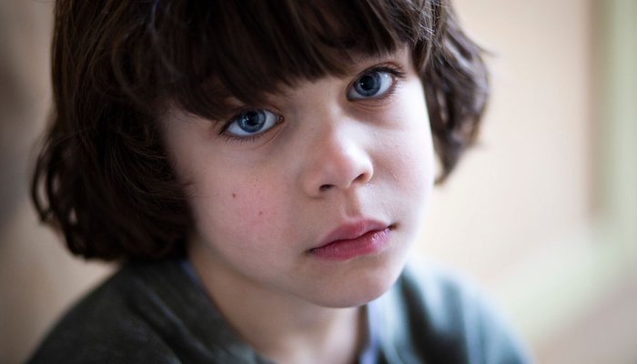Worried young boy looking into camera