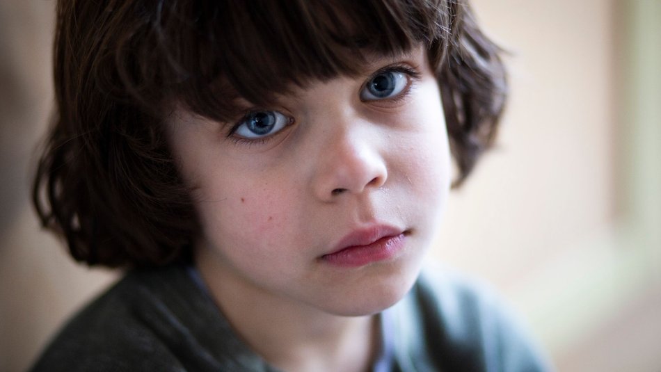Worried young boy looking into camera