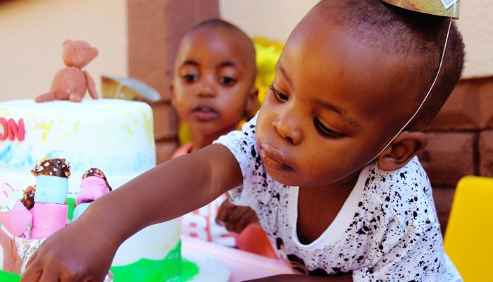 Young boy with birthday hat and cake