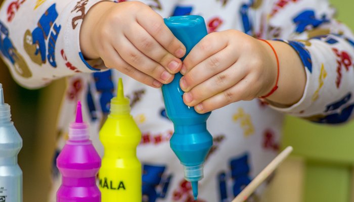 young child squeezing paint bottle.jpg