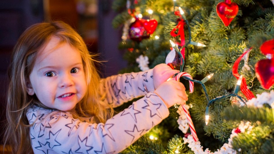 Young girl decorating Christmas tree