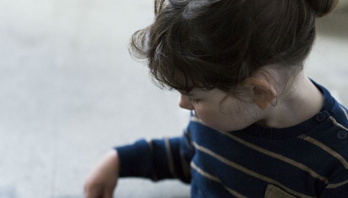 Young girl sat on the floor looking worried