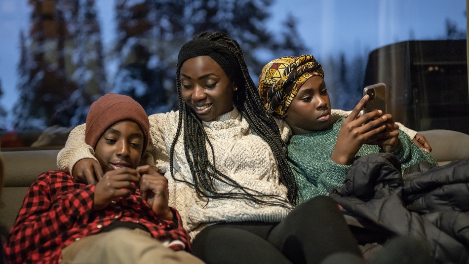 Mother and teenage children relaxing on the sofa