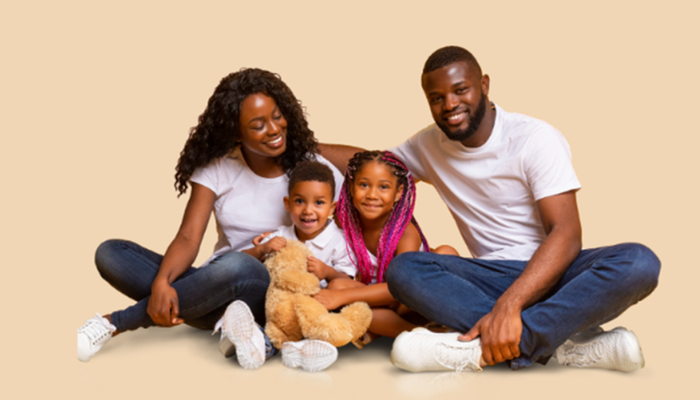 Happy mother and father with son and daughter hugging teddy bear in studio 2